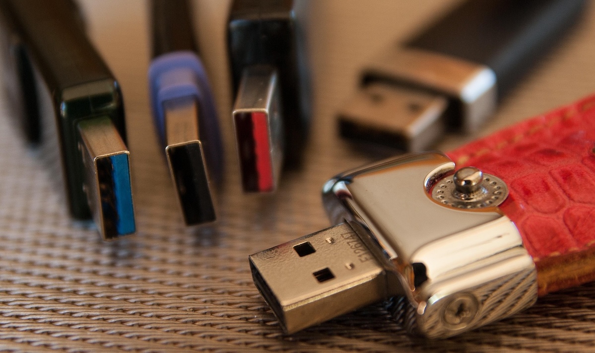 Mano che offre una chiavetta USB — mai accettare pendrive di provenienza sconosciuta per il rischio BadUSB